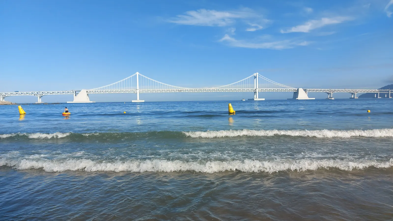 Small waves and the white Gwangan Bridge viewed from Gwangalli Beach in Busan