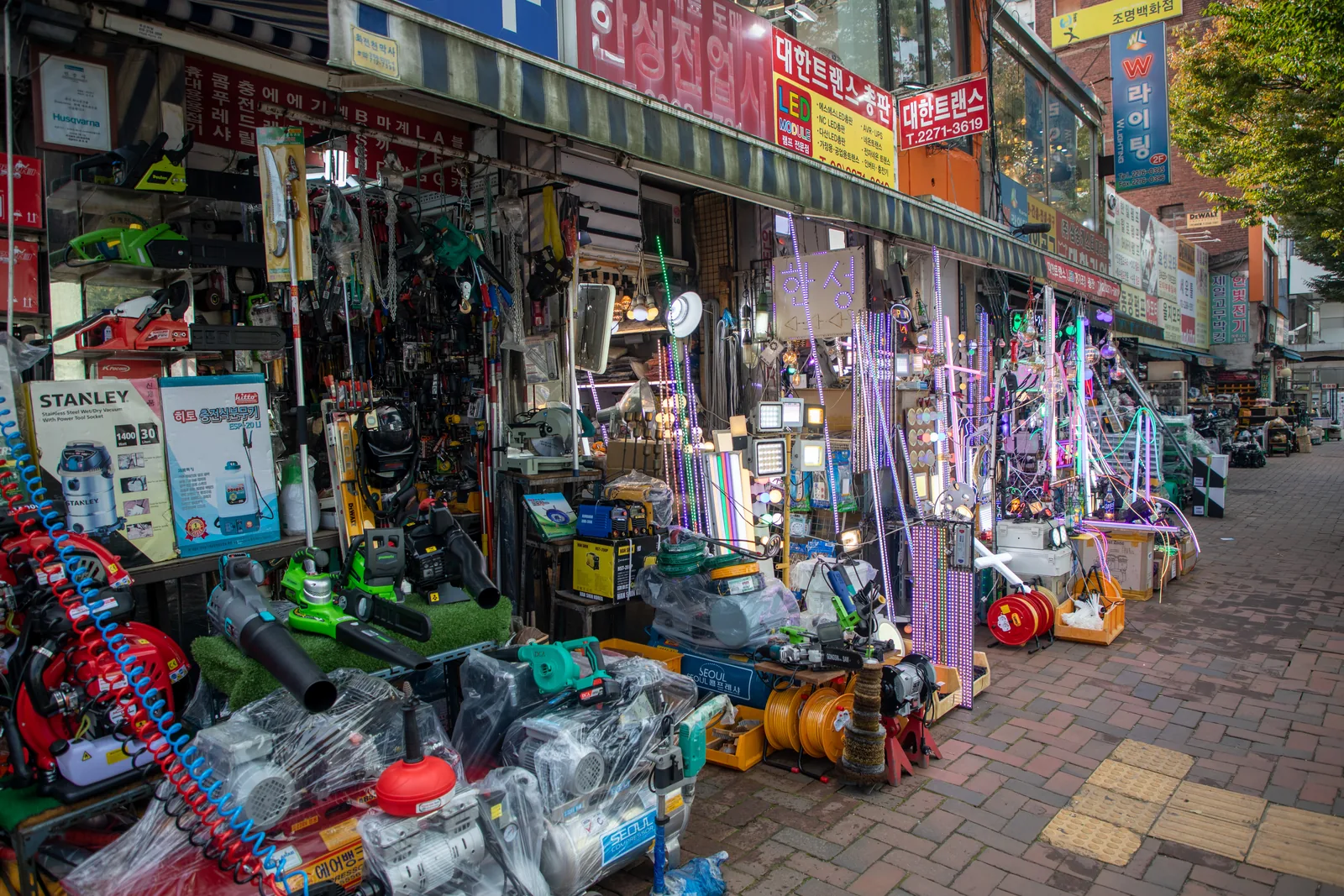 Lighting and hardware shopfronts along a sidewalk in Euljiro, Seoul