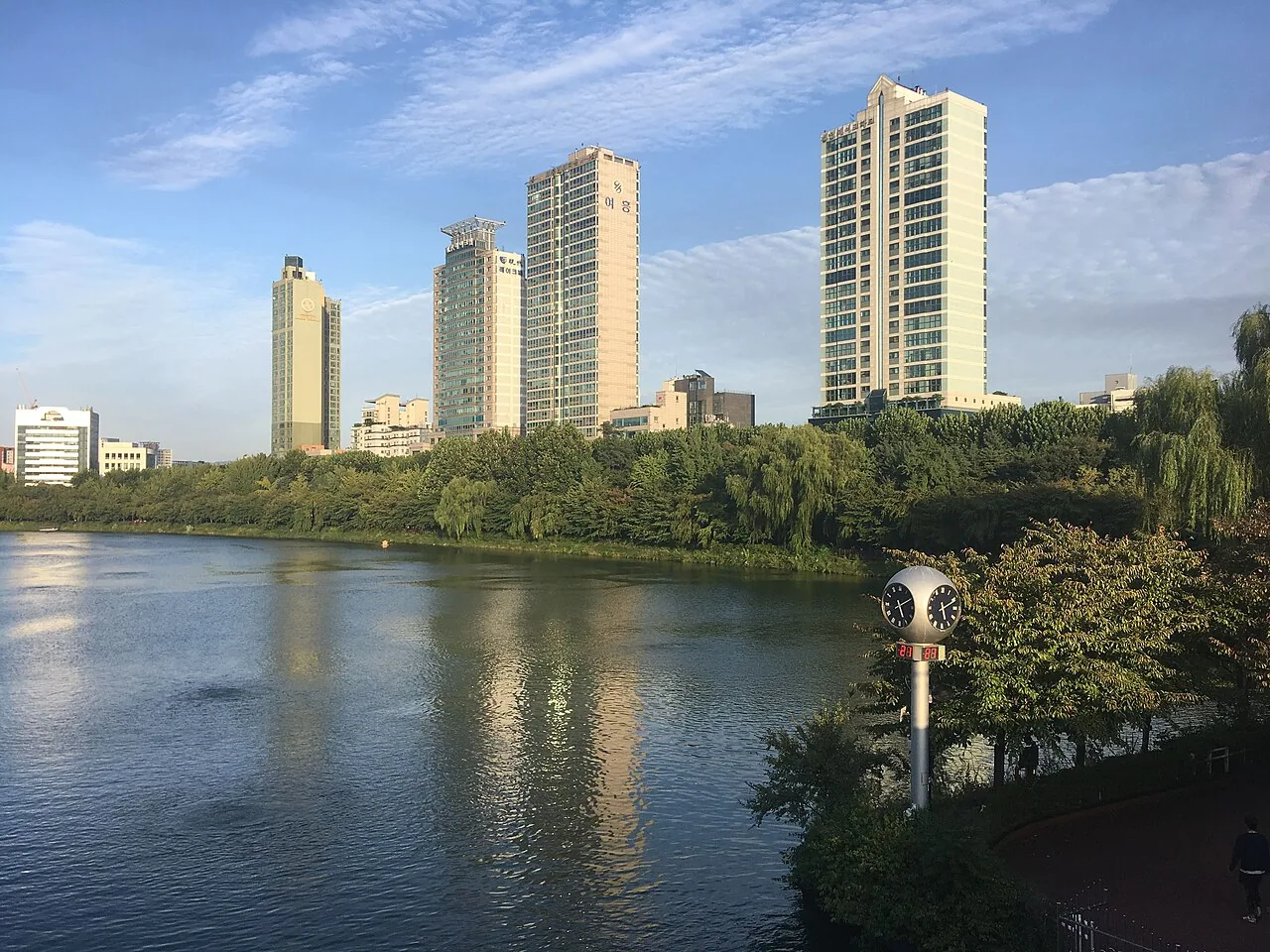 Seokchon Lake with trees and buildings in the Jamsil area of Seoul